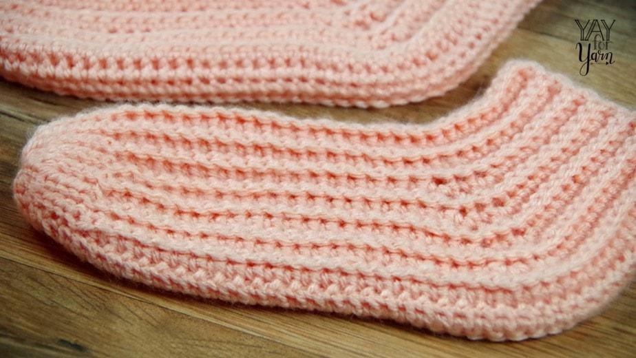 Worked sideways in rows for extra stretch and comfort, these simple crochet socks will keep your toes toasty warm.