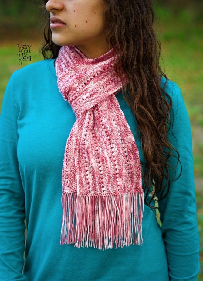 Girl outdoors wearing a blue long sleeves and a wild rose scarf wrapped around the neck