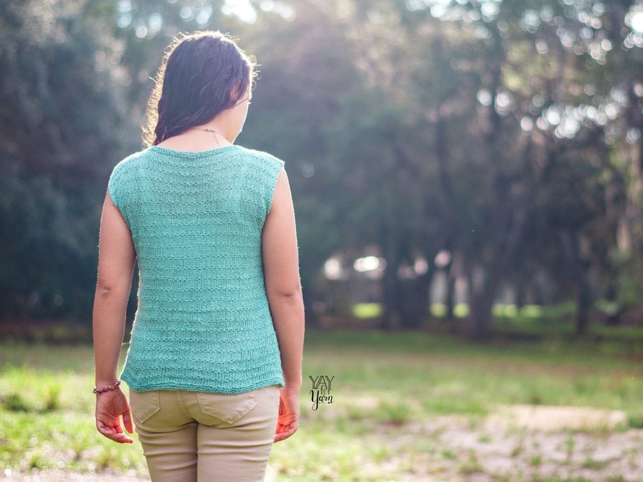 girl wearing light blue-green knitted summer top, walking away