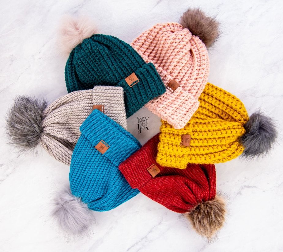 crochet hats on white marble, laid in a circle
