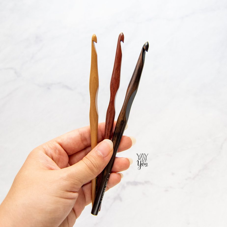 hand holding three laurel hill crochet hooks over white marble